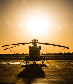 Helicopter on helipad while sun sets