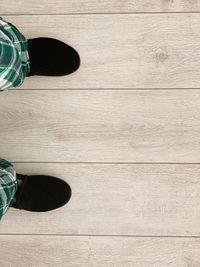 Low section of person standing on wooden floor