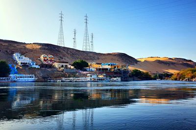 Scenic view of lake by buildings against clear sky