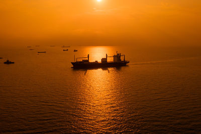 Silhouette boat in sea against sky during sunset