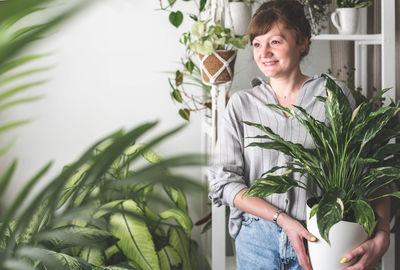 Young woman holding potted plant