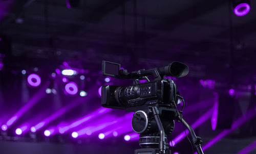 Low angle view of television camera against illuminated spot lights