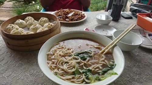 High angle view of noodle soup with chinese dumplings served on table