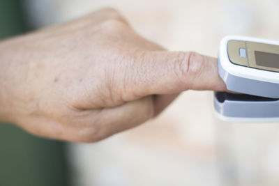 Cropped hand checking blood pressure at home