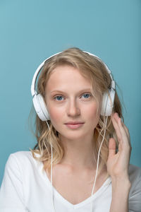 Portrait of teenage girl looking away against blue background