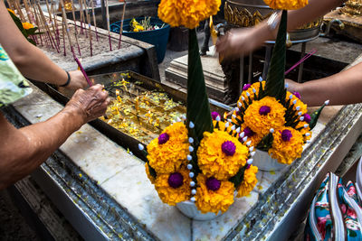 Cropped image of hands offering candles at temple