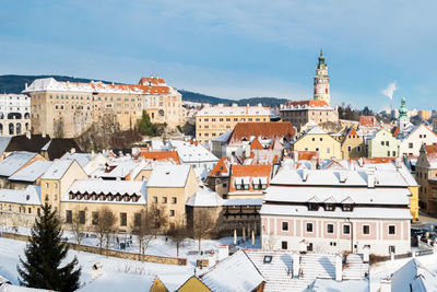 Buildings in town against sky during winter