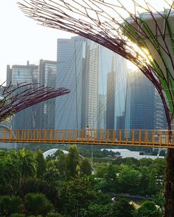Bridge by buildings against sky in city