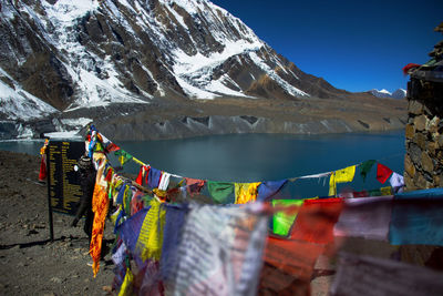 Various flags hanging on mountain against sky