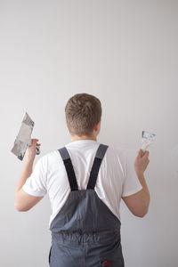 Side view of man using mobile phone against white background