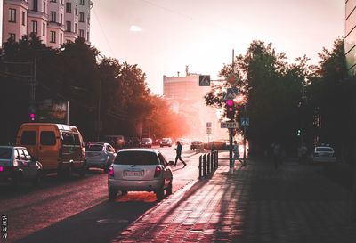 Cars on city street during sunset