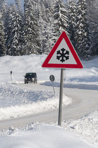 Road sign warns of snow and ice at winter