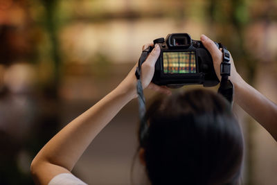 Rear view of woman photographing camera