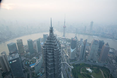 Oriental pearl tower by huangpu river in city