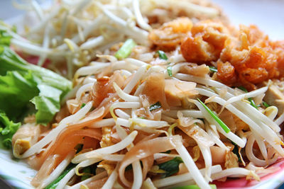 Thailand fried noodles, as pad thai with the chicken, bean sprout, lettuce and green onion