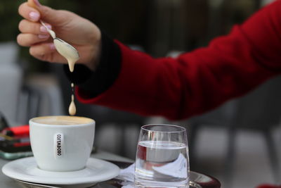 Close-up of hand having coffee at table