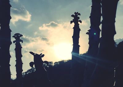 Close-up of silhouette statue against sky