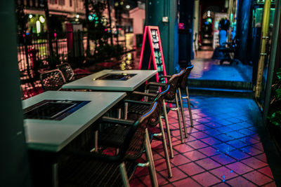 Chairs and tables at restaurant during night