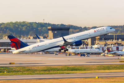 Airplane on airport runway against sky