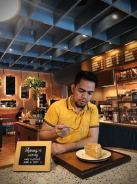 Full length of a man having food in restaurant