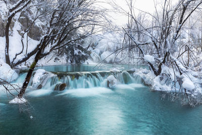 Scenic view of waterfall in forest during winter