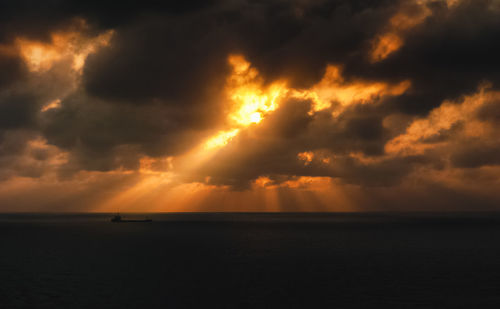 Scenic view of sea against cloudy sky at sunset