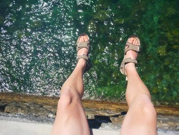 Low section of woman relaxing over lake