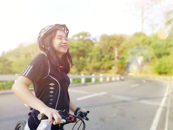 Young woman riding bicycle on road