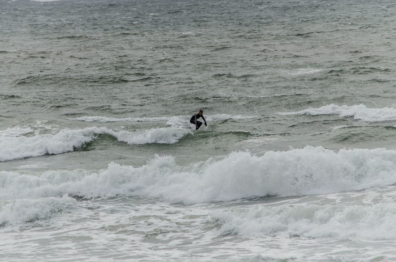 MAN SURFING ON SEA WAVES