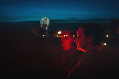 Full length portrait of young man photographing illuminated at night