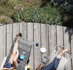 High angle view of women resting on lounge chairs in yard