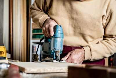 Midsection of carpenter working on wood