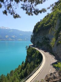 Scenic view of road by sea against sky