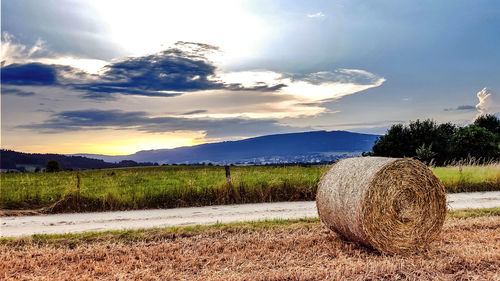 Hay bales on field against sky