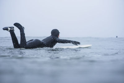 Woman surfing during winter snow