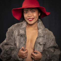 Portrait of sensuous woman wearing hat against black background