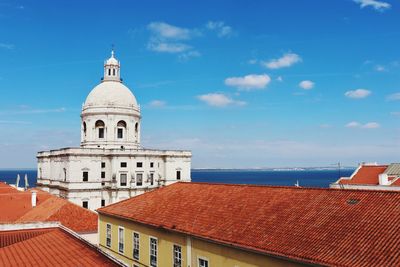 Buildings by sea against sky