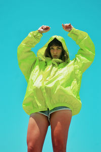 Portrait of young woman wearing hat against blue background