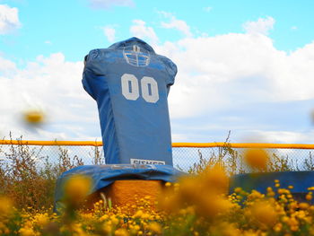 Information sign on field against sky