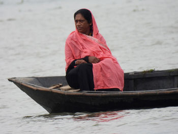 The woman sitting on a floating boat in river