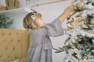 Rear view of girl looking at christmas tree