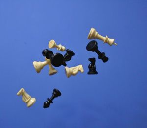 Low angle view of chess pieces against clear blue sky