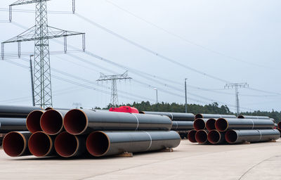 Cars and electricity pylon against clear sky