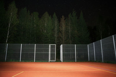 View of empty court against trees at night