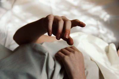 Close-up of hands on bed