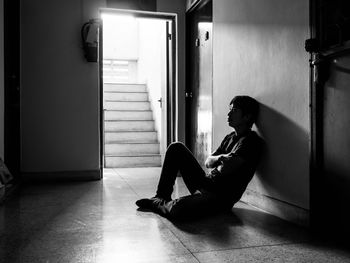 Tensed silhouette man sitting on floor at home