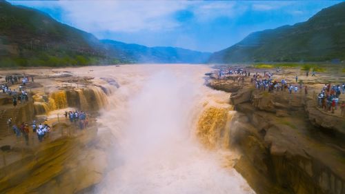 Panoramic view of people on mountain against sky