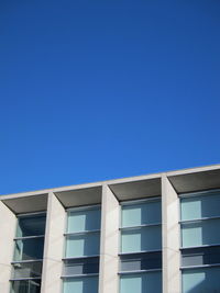 Low angle view of modern building against clear blue sky