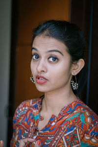 Close-up portrait of woman standing at home