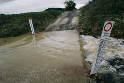 Close-up of text on beach against sky